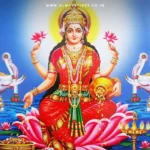 A traditional diya (oil lamp) lit near a Lakshmi idol in a clean, decorated home, symbolizing divine blessings and prosperity