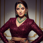 A stunning and glamorous portrait of actress Triptii Dimri wearing a shimmering golden saree with elegant jewelry and a soft, confident expression.
