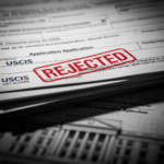 USCIS seal on a folder containing immigration forms and a green card, representing new strict visa rejection policies.