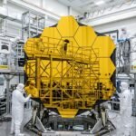 The 2.4-meter primary mirror of the Nancy Grace Roman Space Telescope reflecting light in a cleanroom.