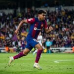 A close-up shot of Lamine Yamal shouting instructions to his teammates during a Champions League match, symbolizing his growing leadership role at Barcelona.