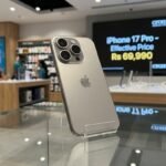 Apple iPhone 17 Pro titanium model on a display stand with a Croma price tag of Rs 69,990 showing bank and exchange offers.