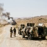 Military vehicles damaged in a convoy attack in Balochistan with security forces cordoning off the area.