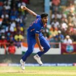 Indian cricketer Washington Sundar bowling during a T20 international match with a focused expression.