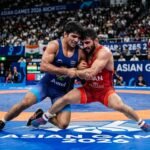Indian freestyle wrestlers training intensely on a professional mat for the upcoming Asian Games.