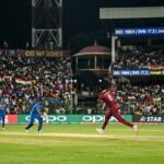 West Indies cricket players celebrating on the field at M. Chinnaswamy Stadium in Bengaluru.