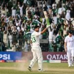 Arafat Minhas celebrating his century against England at the Rawalpindi Cricket Stadium during a high-stakes international match.