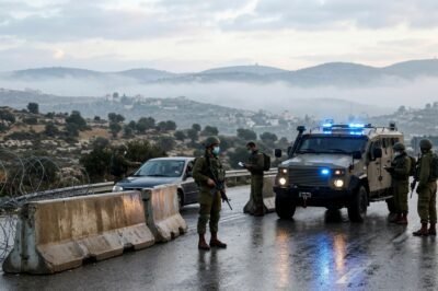 Israeli soldiers and military vehicles stationed at a reinforced checkpoint in the West Bank during a high-alert security lockdown before the elections.