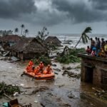 Aerial view of flooded coastal villages in Andhra Pradesh after Cyclone Arnab landfall showing destroyed homes and uprooted trees.