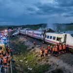 Emergency responders and cranes working at the site of a devastating high-speed train collision in Toledo, Spain, with mangled carriages and debris scattered across the tracks.