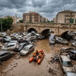 Aerial view of catastrophic flash flooding in Valencia, Spain, showing submerged vehicles and destroyed roads after record-breaking rainfall.