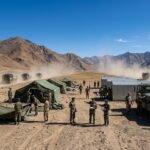 Military vehicles and tents being moved during the disengagement process between Indian and Chinese forces in the high-altitude terrain of Ladakh.